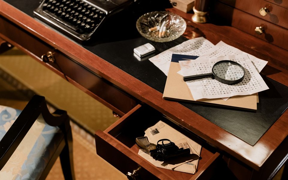 A desk with a magnifying glass and papers